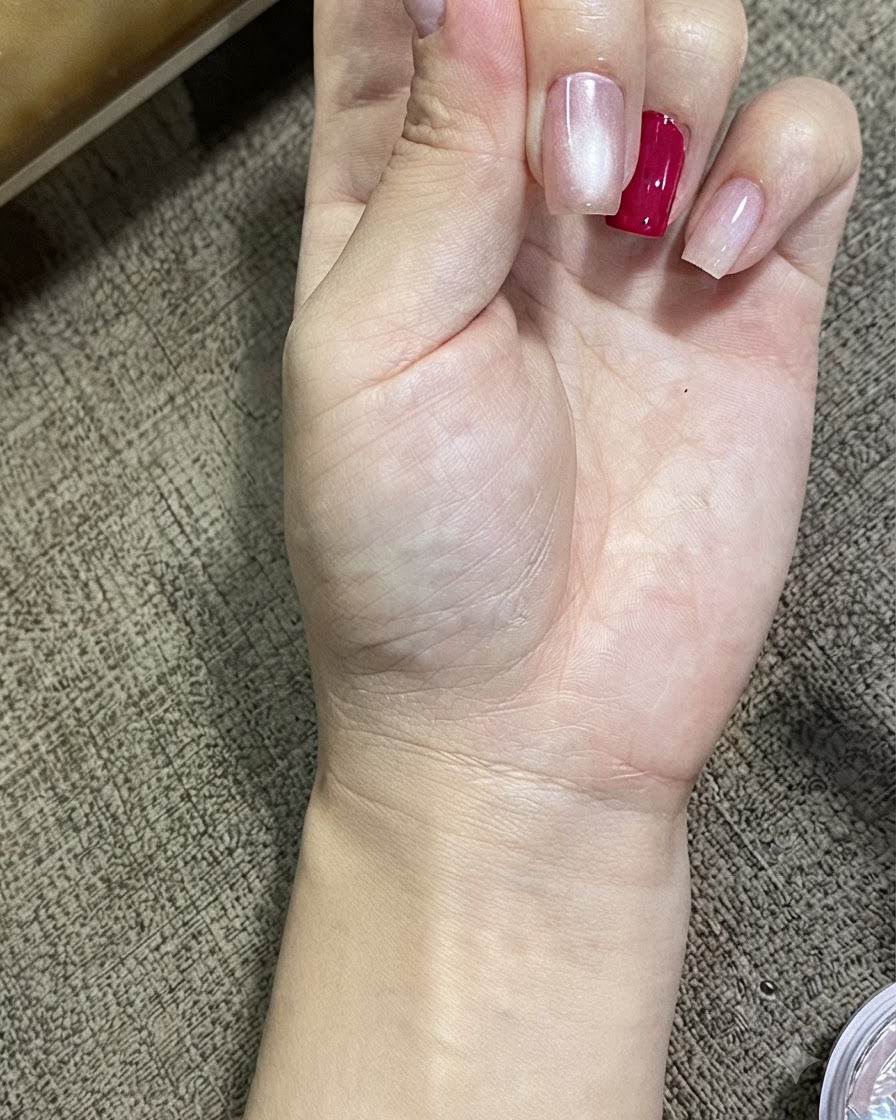 Vue rapprochée dune main présentant des ongles traités avec du gel cat eye magnétique, montrant un effet de sphère lumineuse brillante.