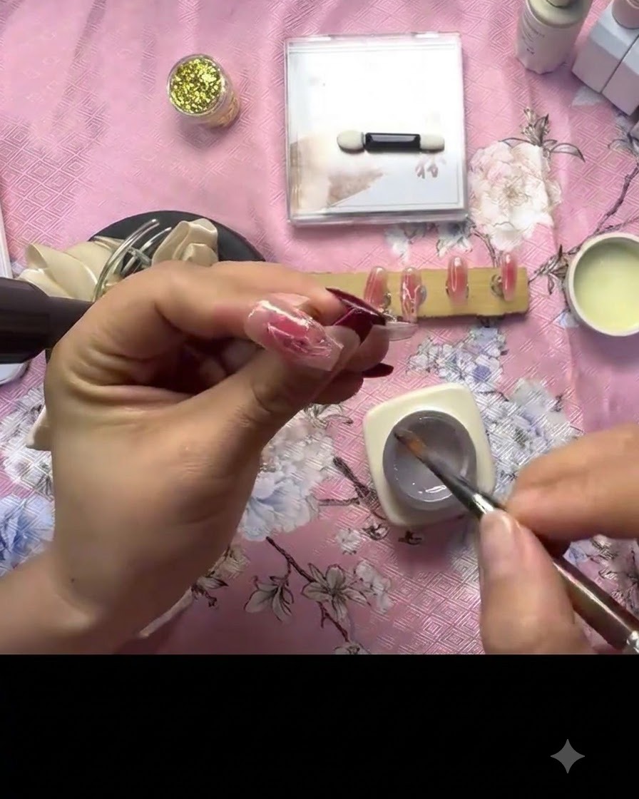 Une main tenant une mini lampe de catalyse UV directement au-dessus dun ongle décoré pour fixer la texture du gel 3D.