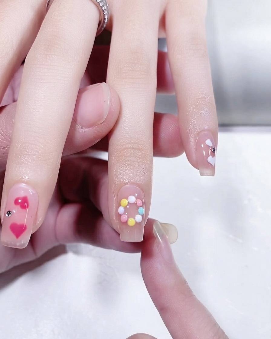 Gros plan dun ongle présentant un design danneau circulaire aux couleurs pastel achevé.
