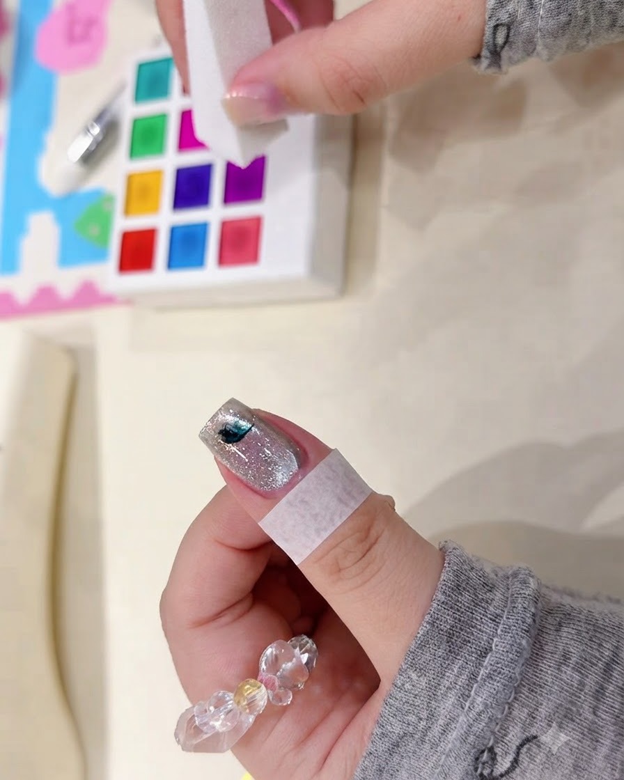 Un bloc éponge tapotant une petite tache sombre de pigment aquarelle sur une surface dongle scintillante.