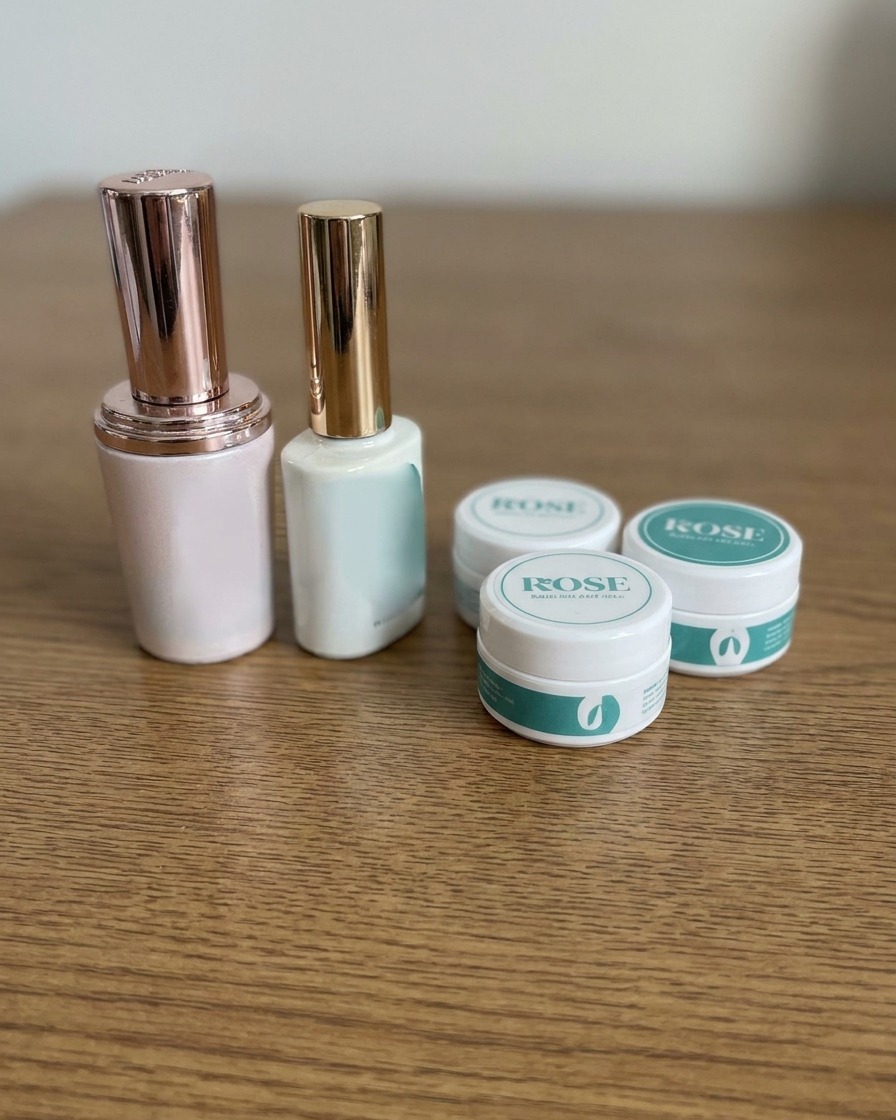 Des bouteilles et des pots de gel pour les ongles disposés soigneusement sur une table en bois.