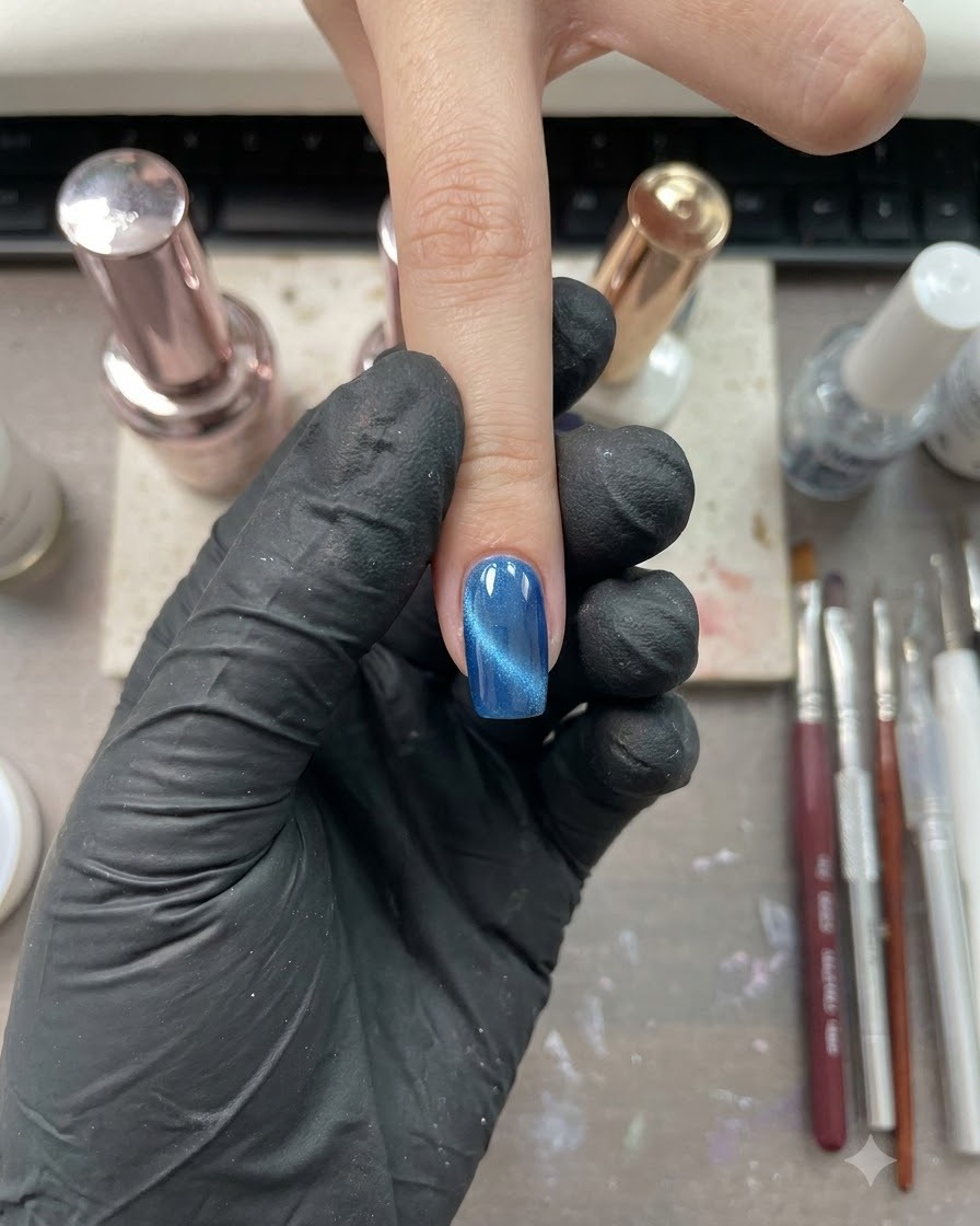Un seul doigt avec une finition brillante cat-eye bleue positionné dans un environnement de studio donglerie.