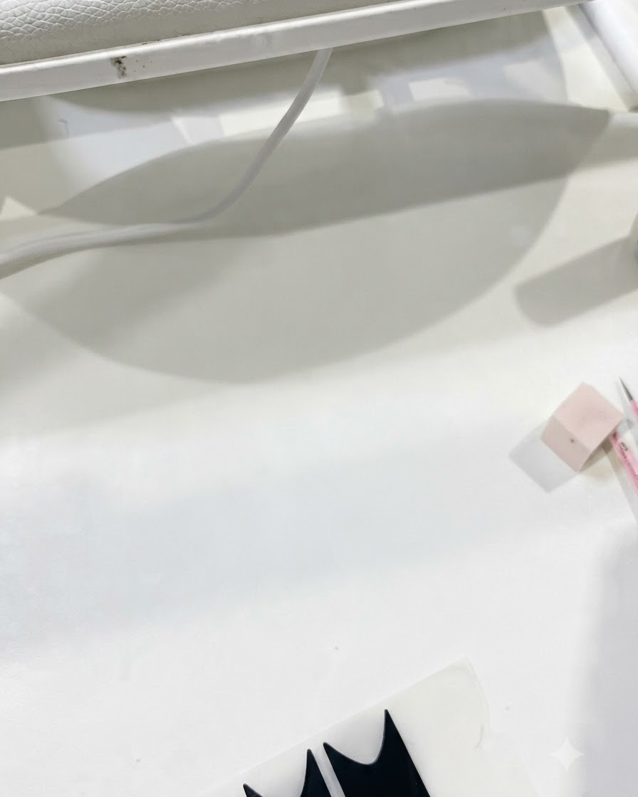 Une vue de lespace de travail montrant les produits dapplication pendant la préparation du top coat pour la structure de longle.