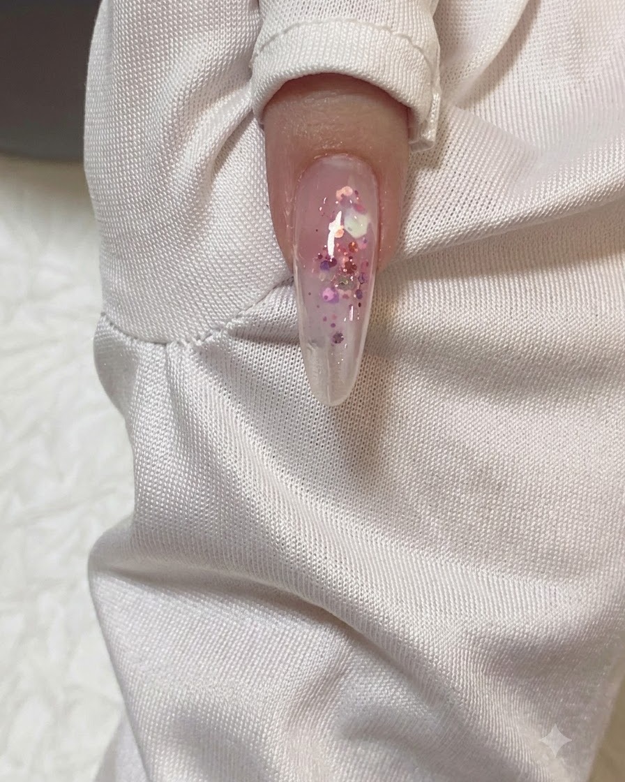Une vue rapprochée dun ongle en forme damande recevant une couche transparente de gel de construction.