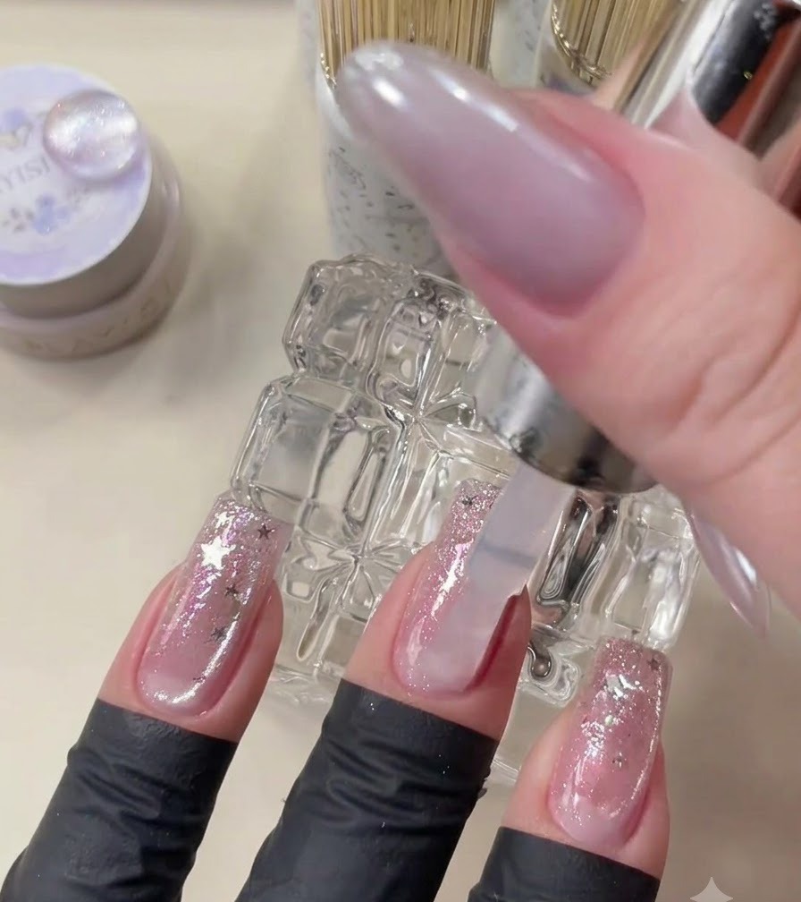 Un pinceau de top coat appliquant du gel transparent sur le nail art terminé.