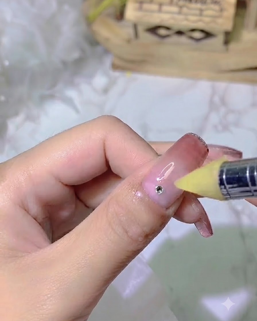 Un outil pour ongles appliquant un point précis de colle adhésive forte sur un ongle dégradé.
