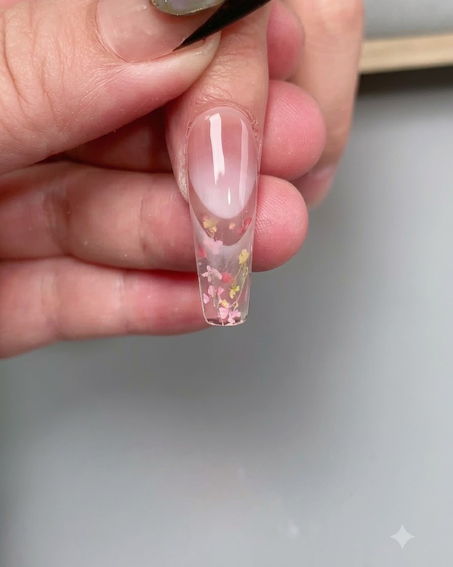 Gros plan dun ongle en train de catalyser sous la lueur rose dune lampe à ongles UV/LED.