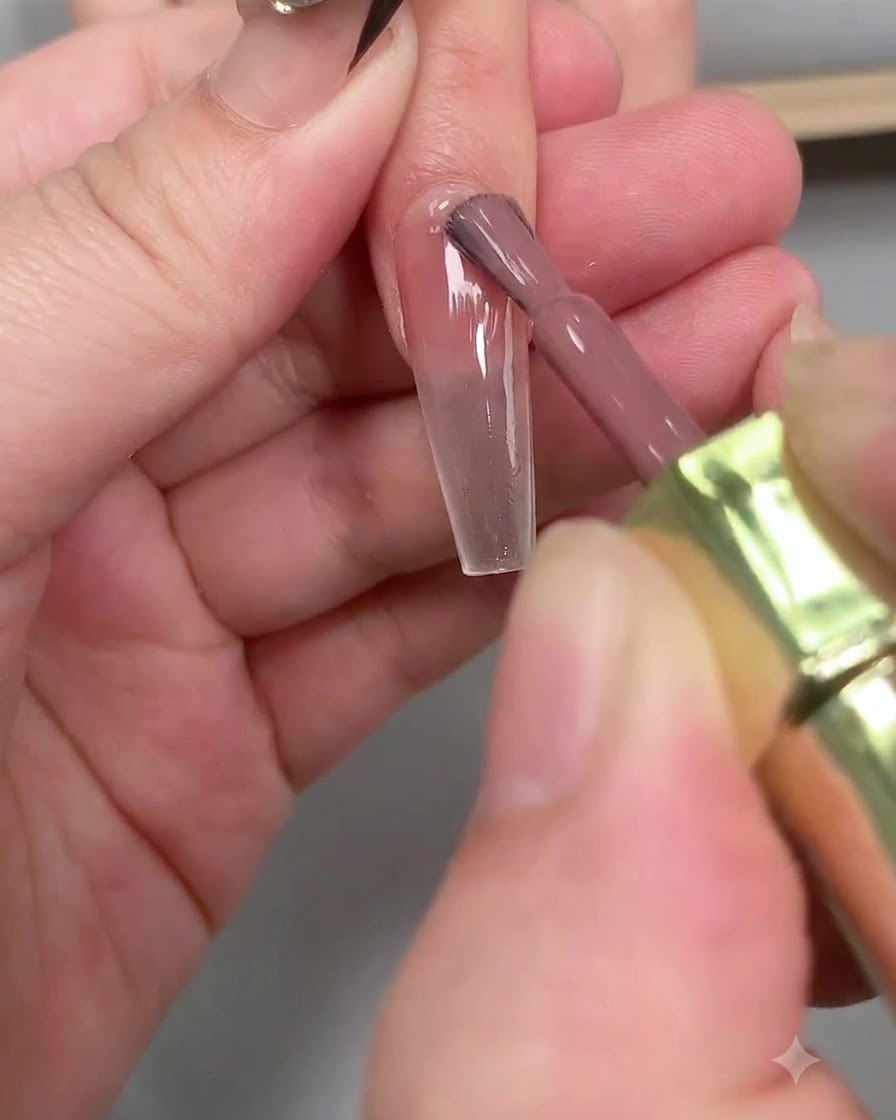 Une pince à épiler retirant délicatement un autocollant guide French blanc dun ongle allongé en forme de cercueil.