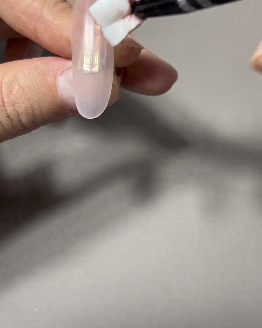 Une éponge de maquillage utilisée pour tapoter et fondre les bords du dégradé sur un ongle.