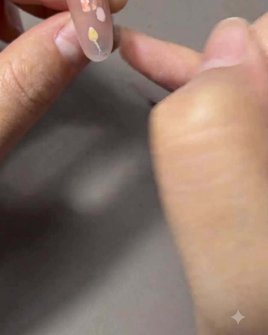 Un pinceau fin peignant de fines tiges et feuilles vertes reliées à une tulipe.