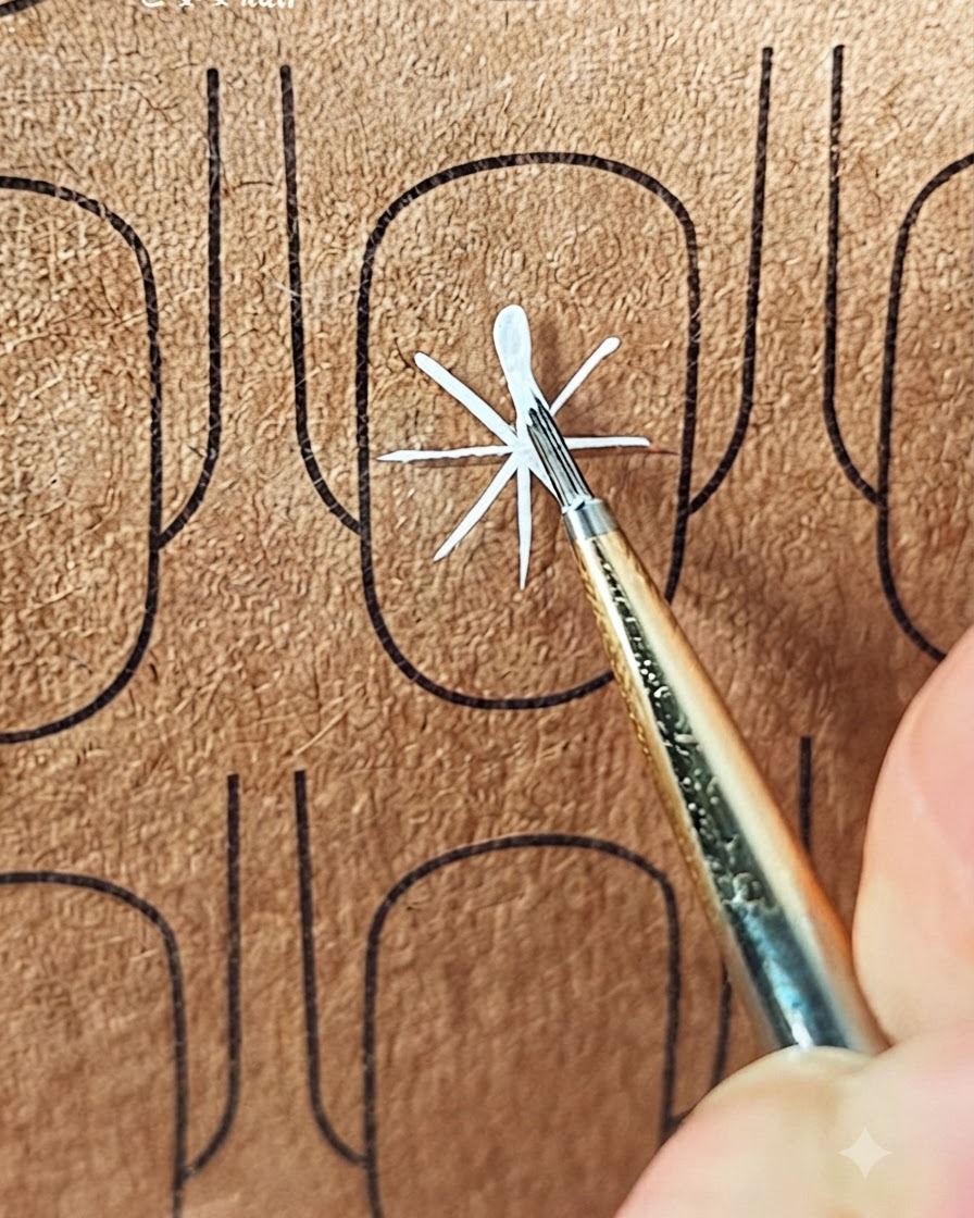 Un pinceau fin créant le premier trait dun pétale blanc vers lextérieur à partir du centre des lignes de guidage.