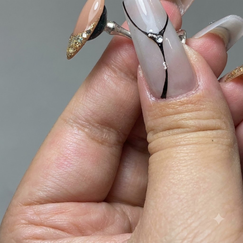 Un pinceau pour ongles étalant du gel platine doré sur le bout dun ongle dentraînement.
