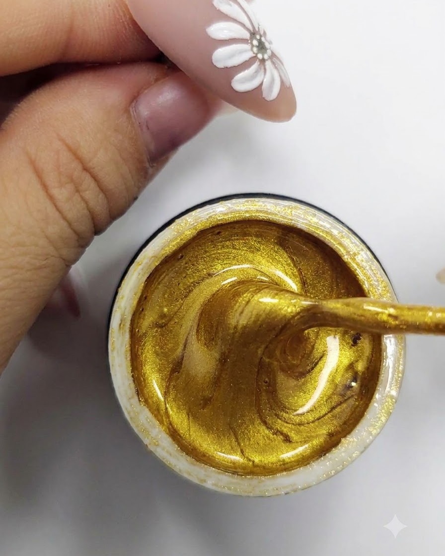 Un pinceau liner fin prélevant et chargeant du gel vernis doré scintillant à lintérieur dun pot ouvert.