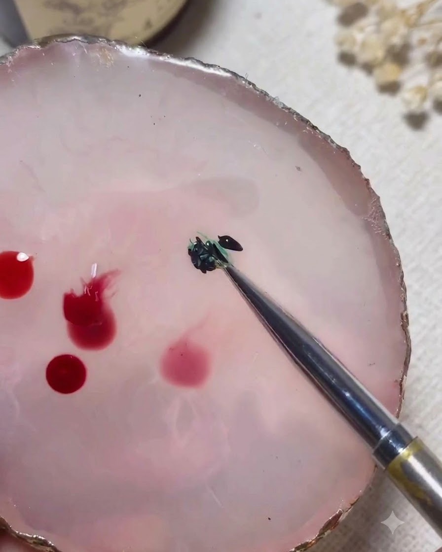 Un outil de mélange combinant des gels vert et noir ensemble sur une palette en marbre rose.