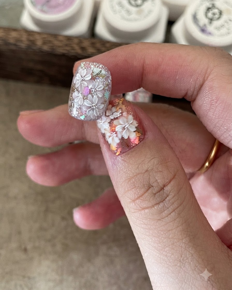 Un petit pinceau déposant des flocons de foil iridescents sur une base dongle collante.