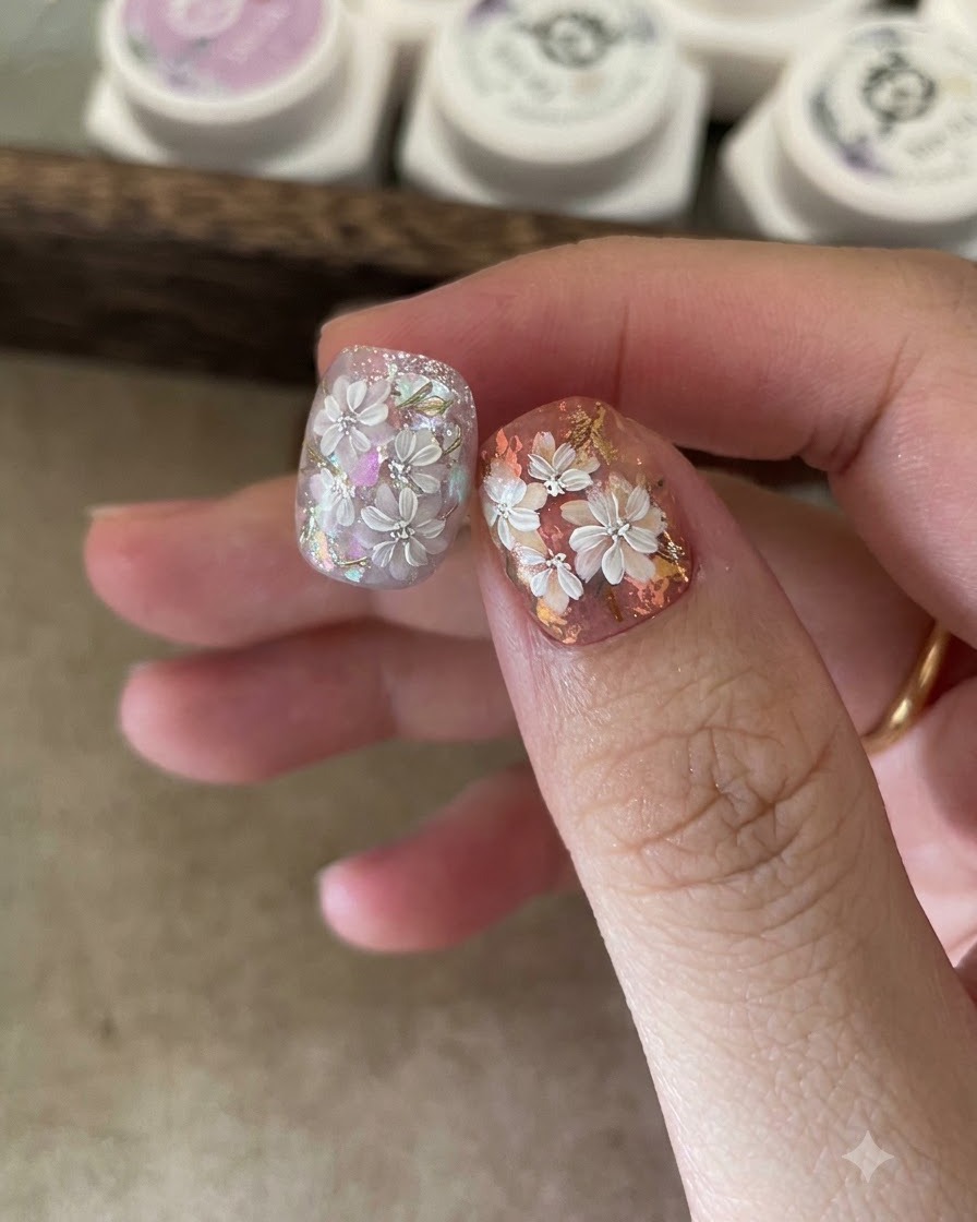Une éponge applicatrice frottant de la poudre effet miroir dorée sur les détails de feuilles peintes dun ongle.