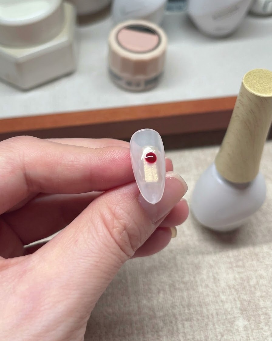 Un seul point de gel rouge sétalant légèrement sur une surface dongle transparente.