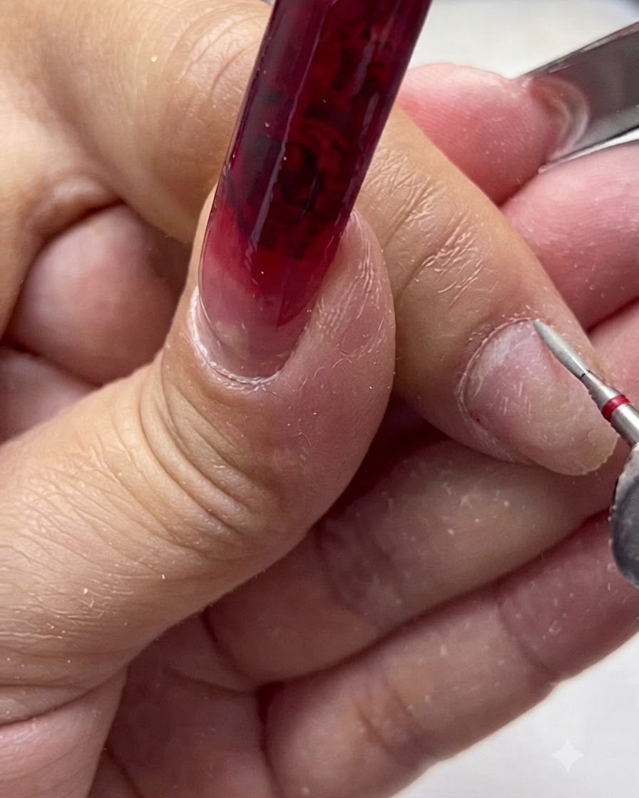 Une ponceuse à ongles électrique munie dun embout céramique de sécurité travaillant le contour de longle naturel.