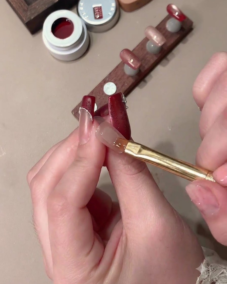 Un aimant façonnant le gel œil-de-chat sur un ongle pour créer un effet de lumière large avec un espace de French tip clair.