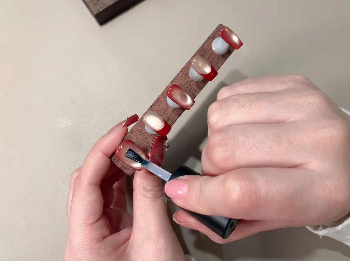 Un pinceau appliquant un top coat transparent pour sceller lart ongulaire terminé.