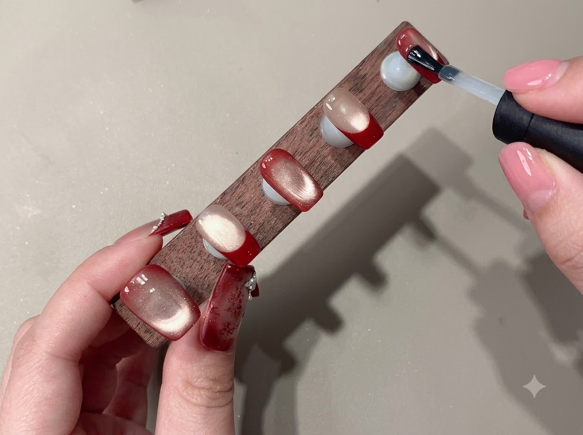 Un pinceau appliquant du gel rouge sur une plaque de stamping métallique gravée.