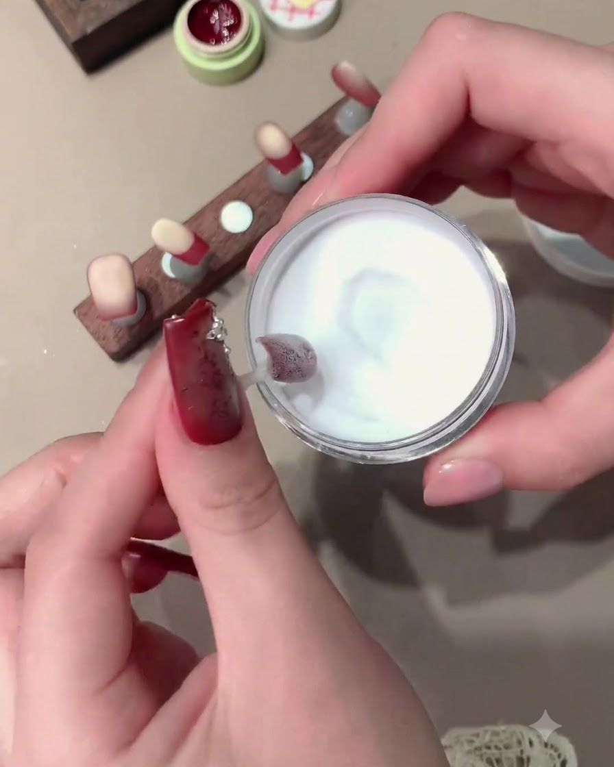 Une mini lampe de catalysation rouge tenue au-dessus dun ongle pour catalyser le produit.