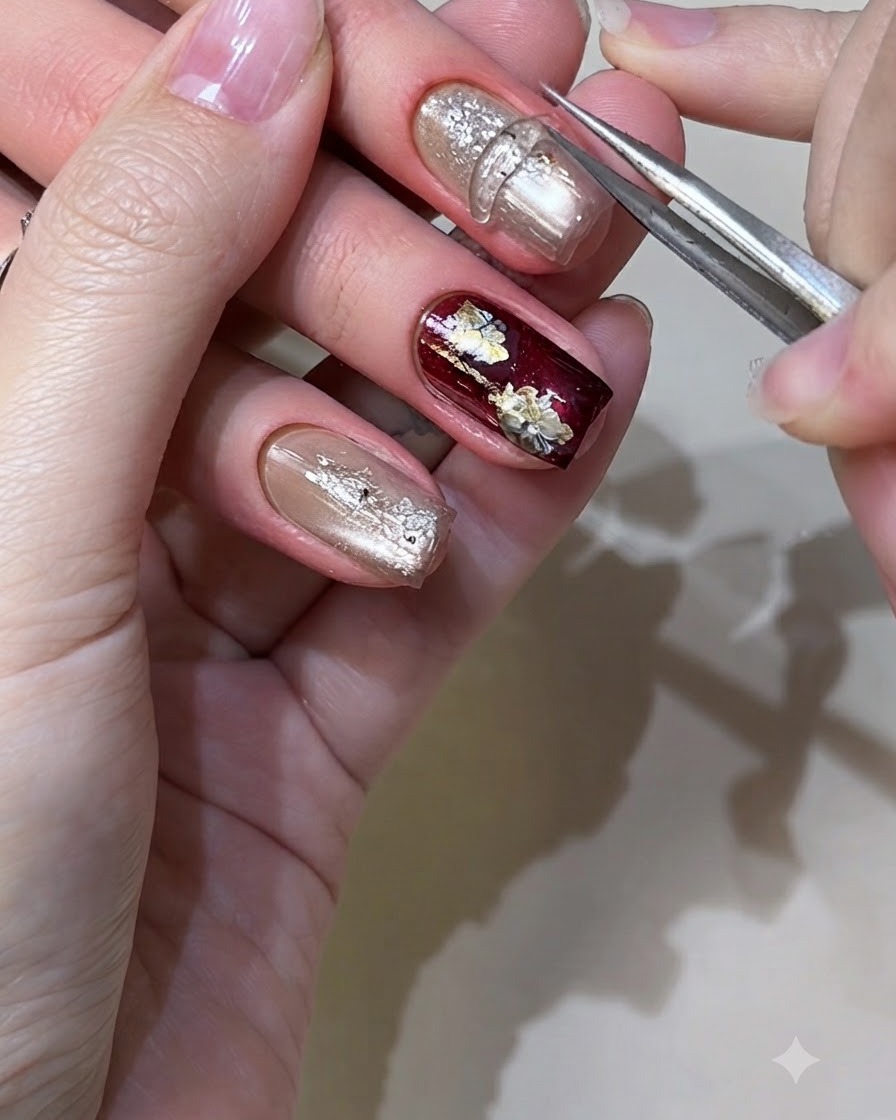 Une pince ou un outil en silicone pressant un élément en gel solide moulé sur un ongle doré métallisé.