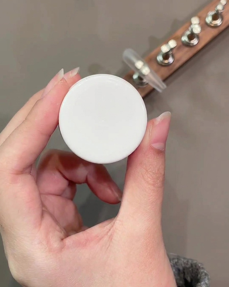 Un pinceau plat à gel appliquant une couche lisse de couleur de base nude numéro 34 sur la surface de longle.