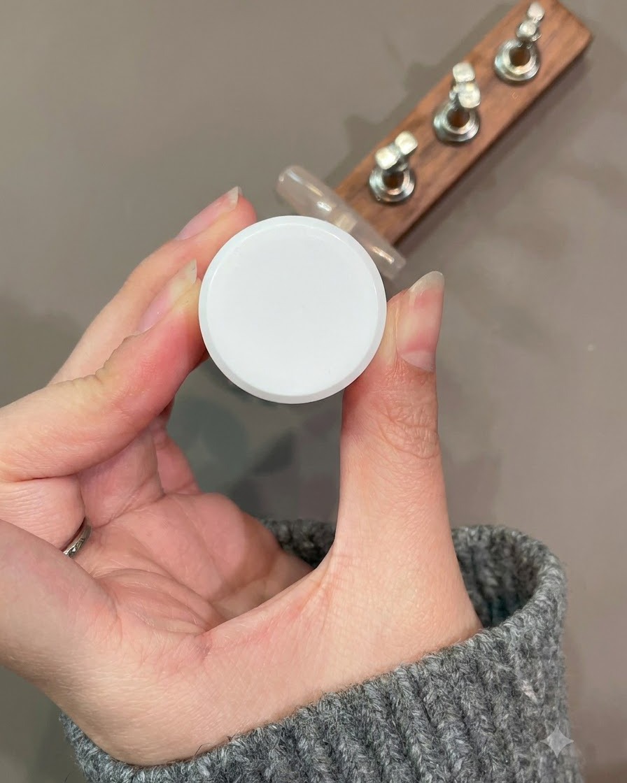 Un pinceau liner fin dessinant une courbe de French manucure en gel œil-de-chat rouge foncé sur le motif de dentelle.