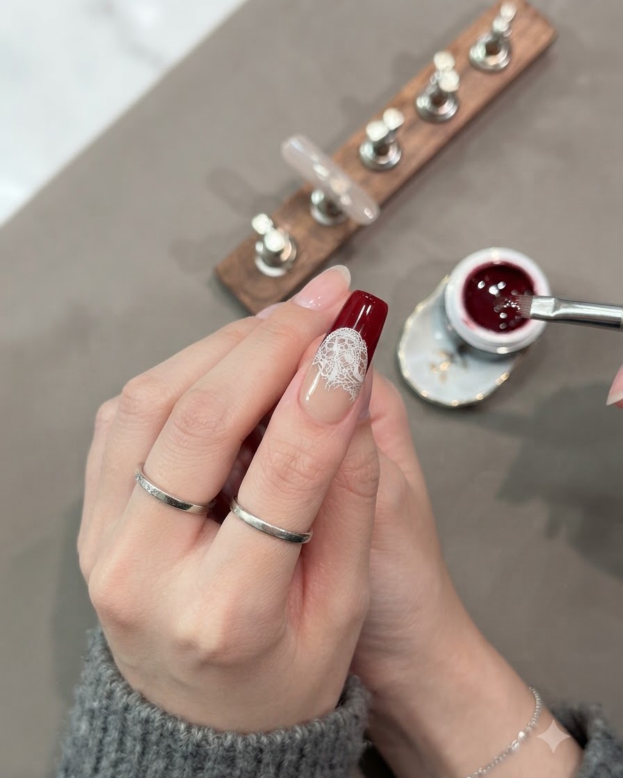Un pinceau remplissant complètement la section inférieure de longle avec du gel œil-de-chat rouge foncé.
