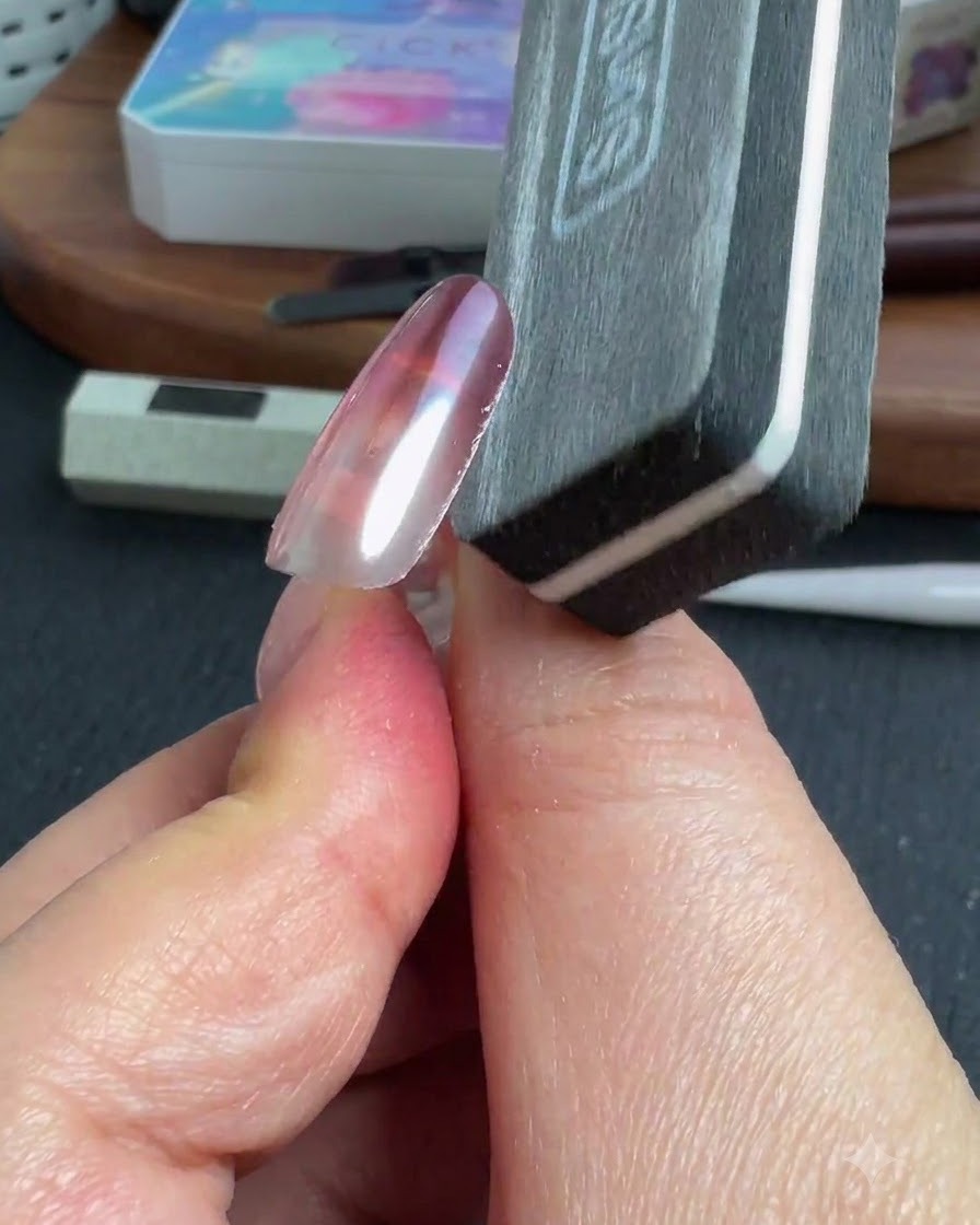 Une lime à ongles façonnant le bord latéral dun ongle chromé terminé.