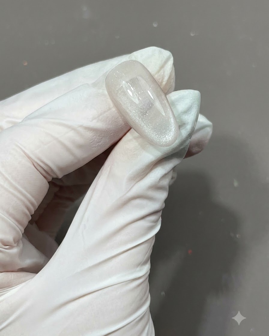 Pinceau appliquant une couche de top coat mat sur un ongle texturé et encapsulé détoiles.