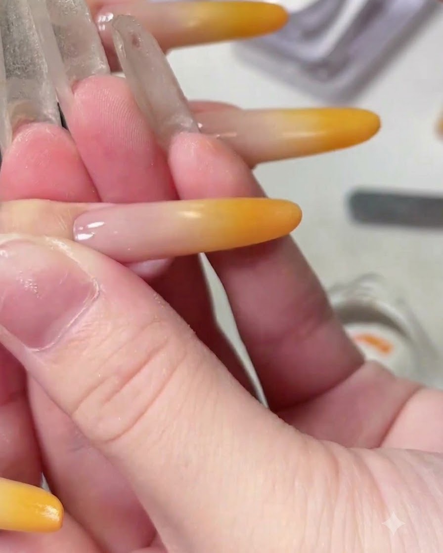 Gros plan dun pinceau liner fin dessinant une ligne courbée délicate sur un ongle dégradé terminé.