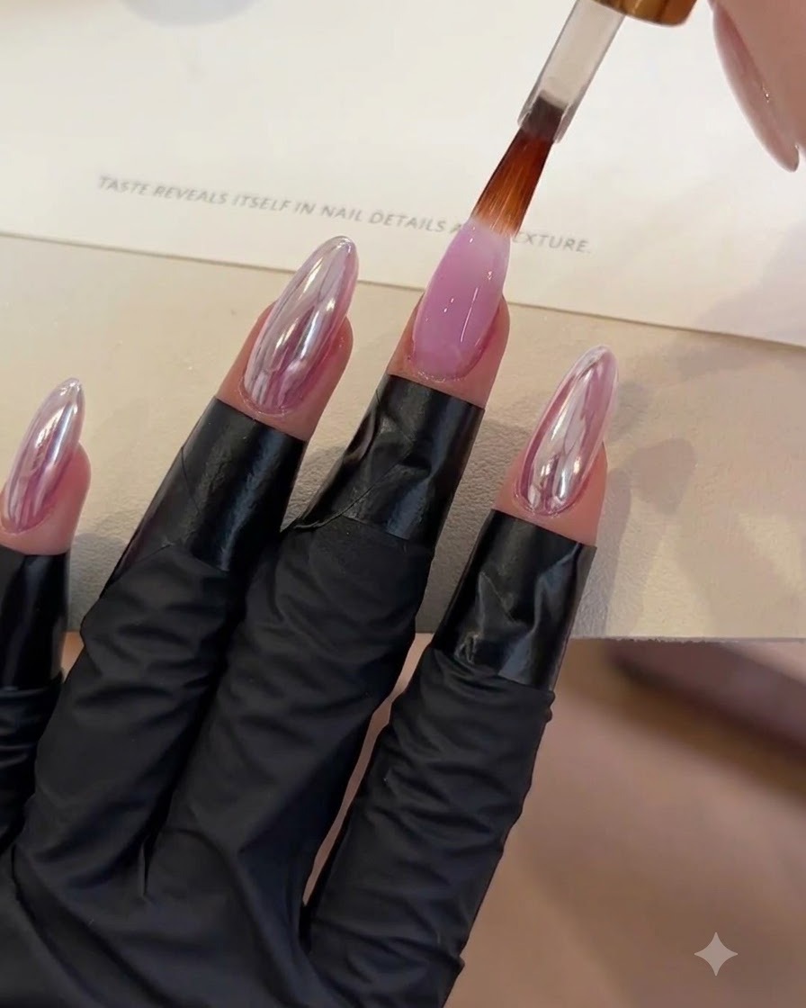 Un pinceau appliquant une couche de top coat transparent sur un ongle en gel violet.