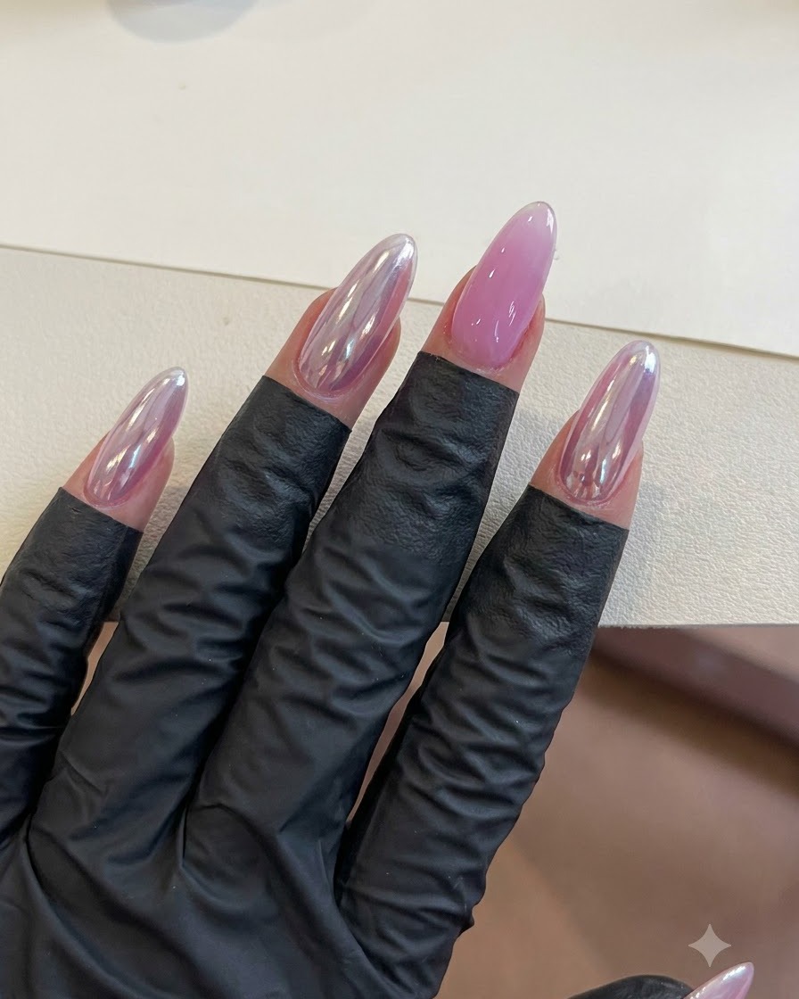 Une main avec des ongles en gel violet finis reposant sous un éclairage pendant létape de catalysation.