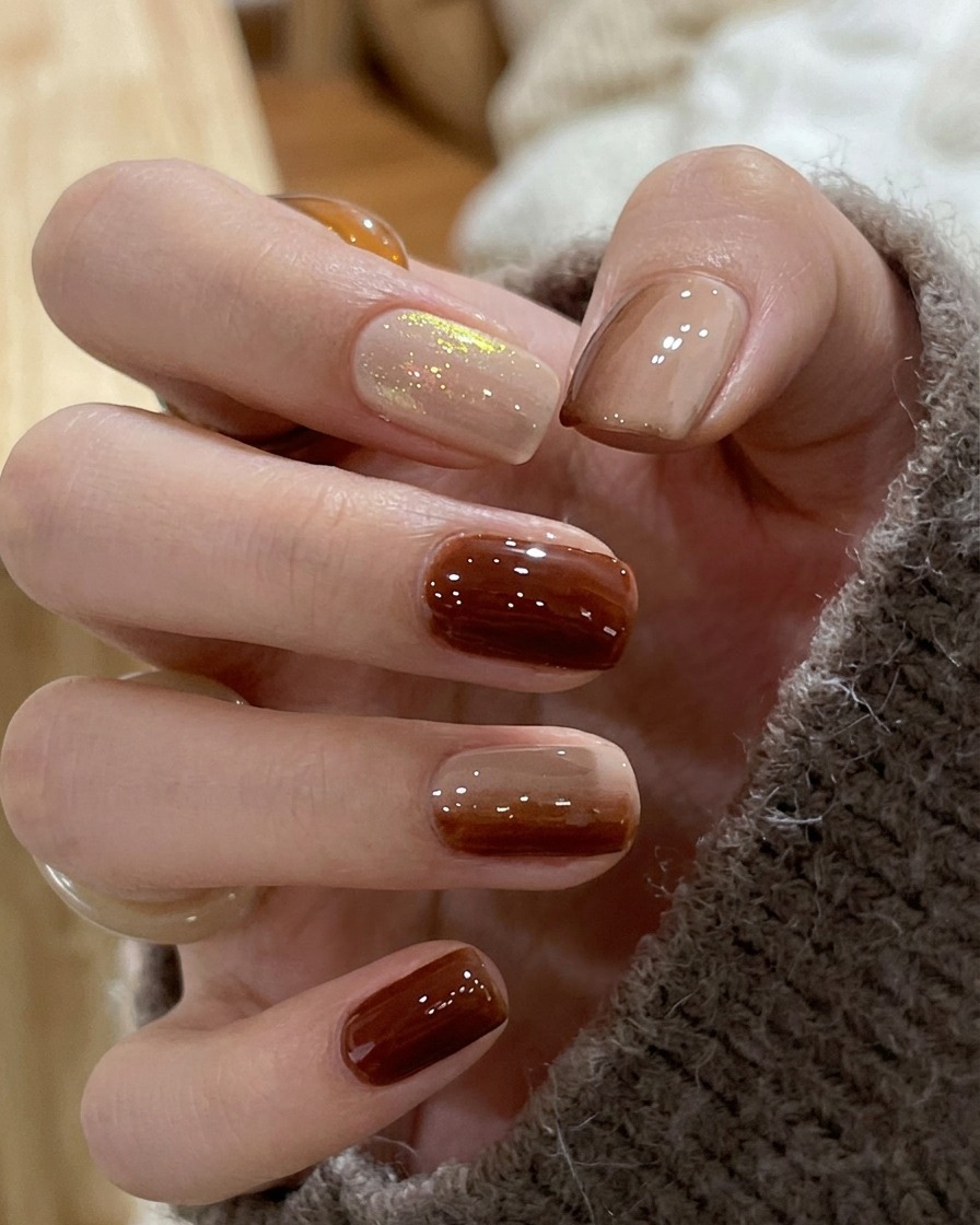 Gros plan dun ongle montrant la jonction floue entre le vernis marron et nude pour former un dégradé lisse.