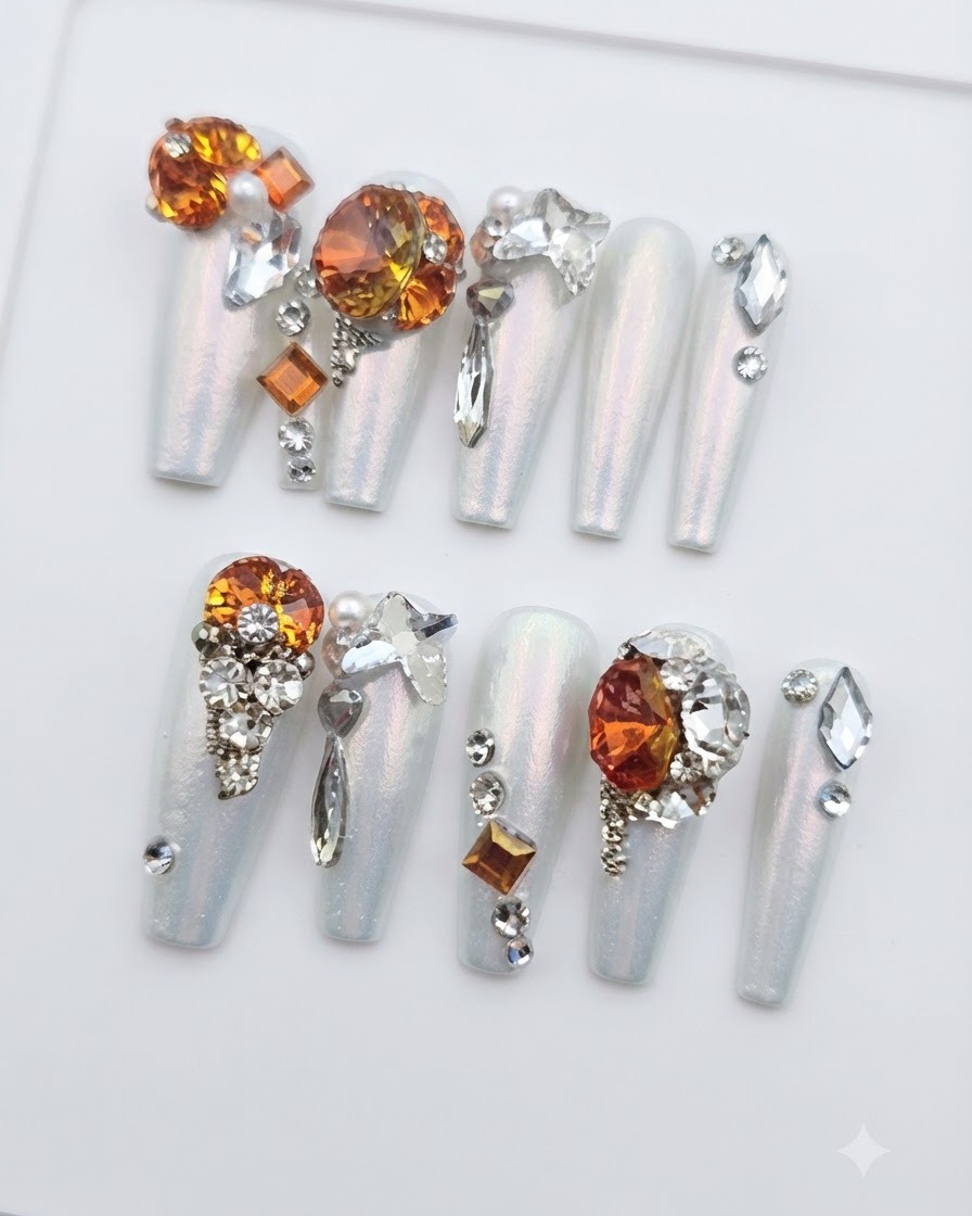 Une vue aérienne de dix ongles press-on décorés disposés ensemble, montrant les placements individuels des pierres et les reflets de lumière.