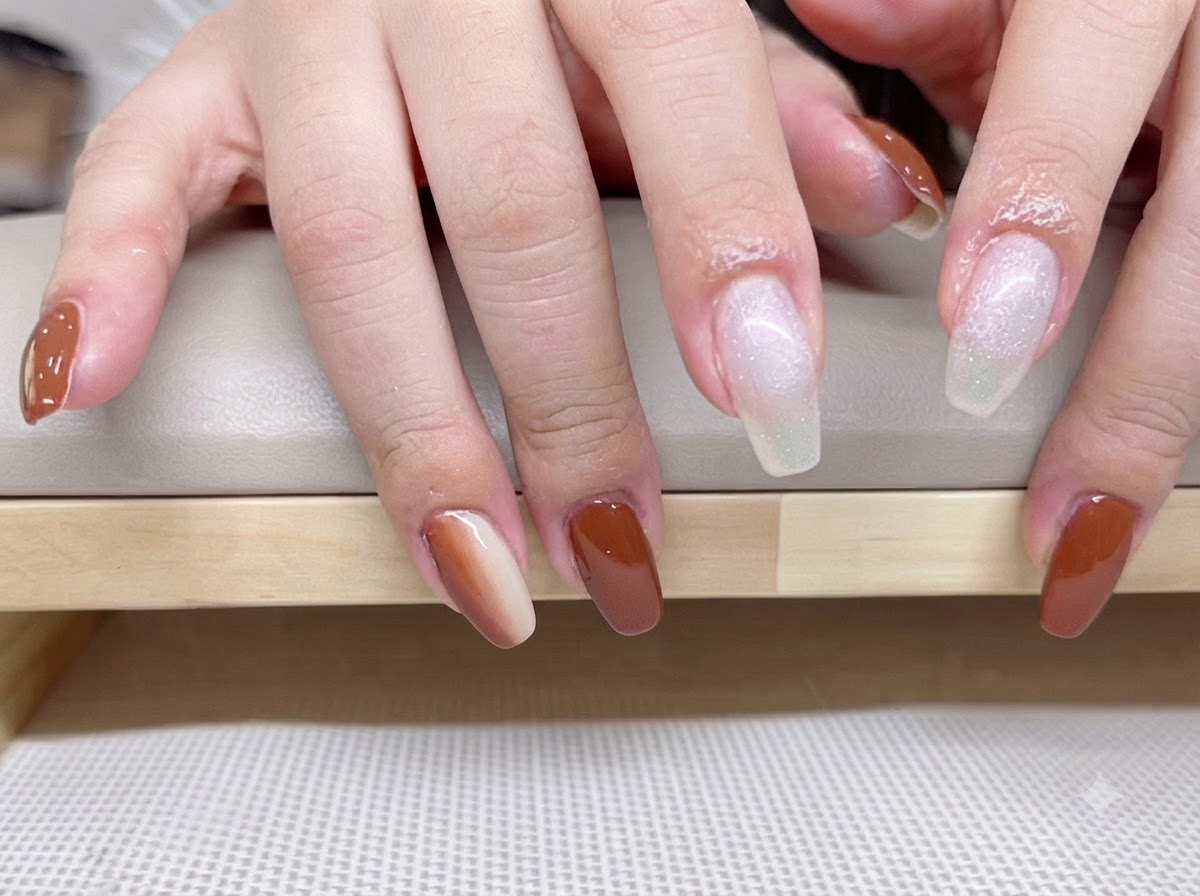 Gros plan de mains avec une couche de base translucide blanc laiteux appliquée sur les doigts index et majeur.