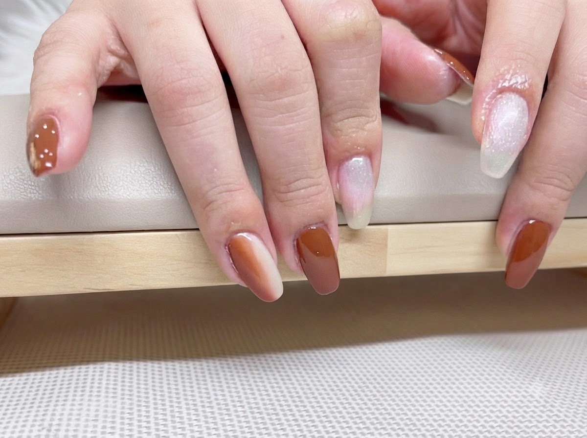 Macro détaillée de la pose dongles en gel caramel et ambre finie reflétant la lumière sous un top coat brillant.