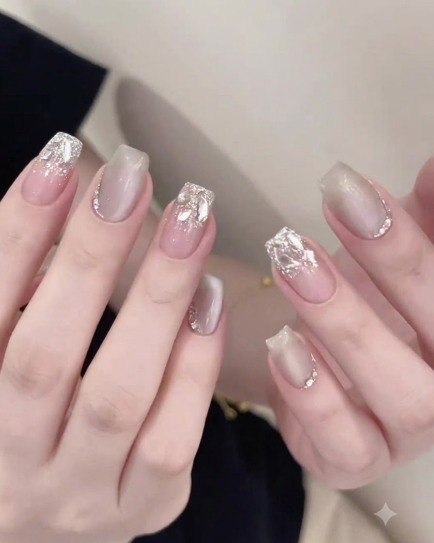 Un pinceau à ongles appliquant soigneusement un top coat brillant autour de strass incrustés sur un ongle terminé.