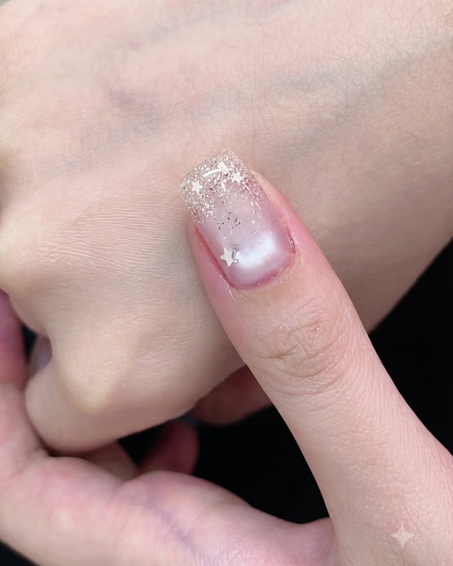 Un pinceau à gel recouvrant un onglet de vernis gel cat-eye blanc transparent.