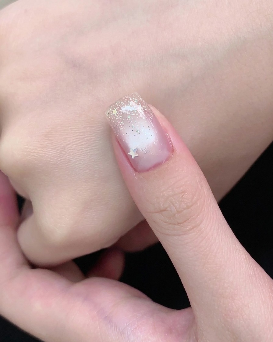 Un aimant en barrette maintenant une ligne de scintillement lumineuse concentrée au centre dun ongle en gel cat-eye.