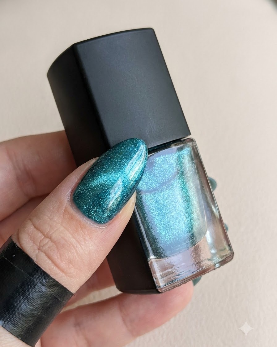 Un flacon de top coat à côté dun ongle catalysé prêt pour la poudre magique.