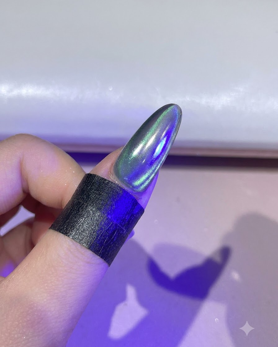 Un ongle illuminé sous une lampe de catalysation UV/LED violette.