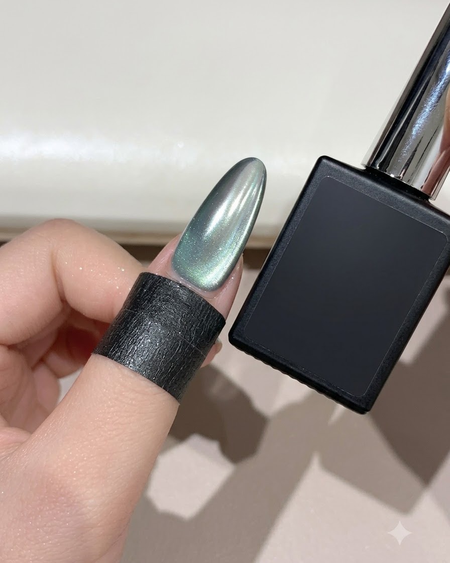 Un ongle en amande fini effet œil-de-chat croissant de lune brume cyan à côté dun flacon de gel noir.