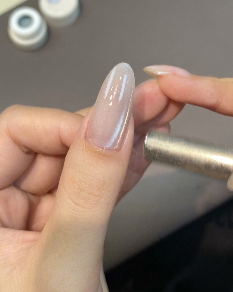 Un petit bâtonnet aimanté positionné près dun ongle pour activer les particules du gel cat eye.