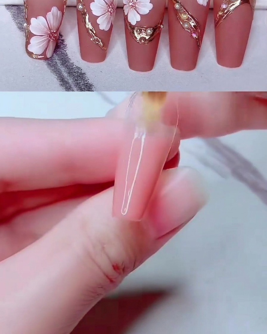 Un outil fin de nail art plaçant de petites perles blanches sur la surface décorée de longle.