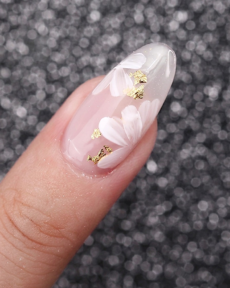 Un gros plan de pétales de fleurs blancs peints se chevauchant sur un fond dongle en gel.