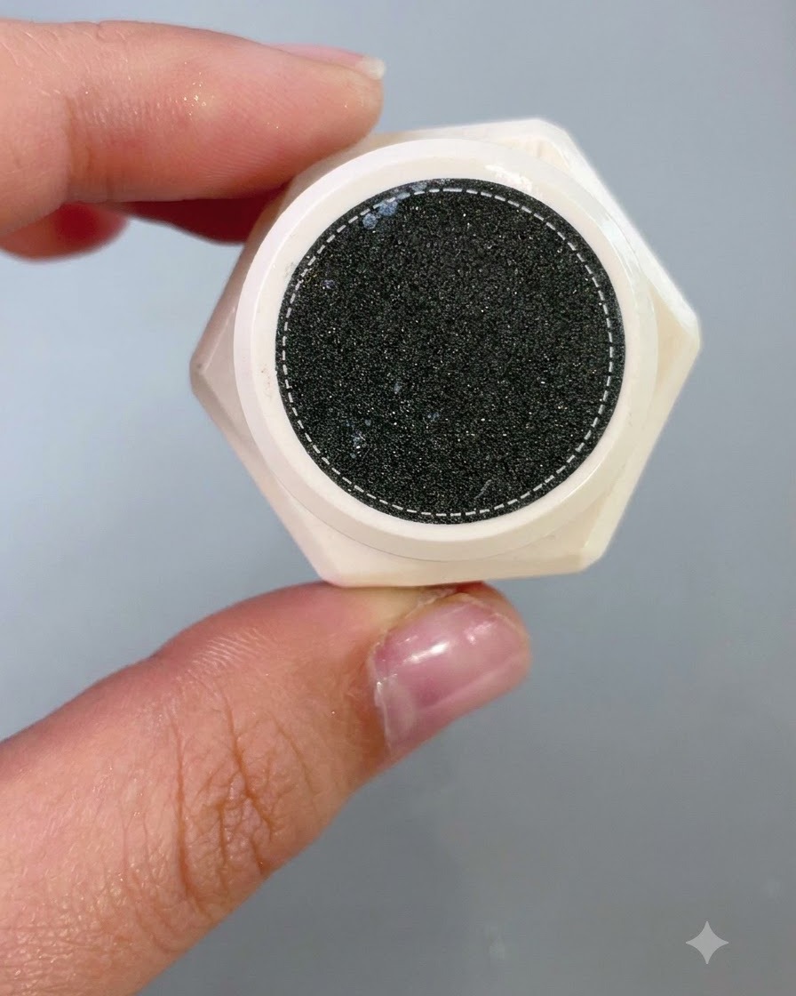 Vue rapprochée regardant à lintérieur du pot ouvert dun produit de modelage texturé à la surface sombre et mouchetée.