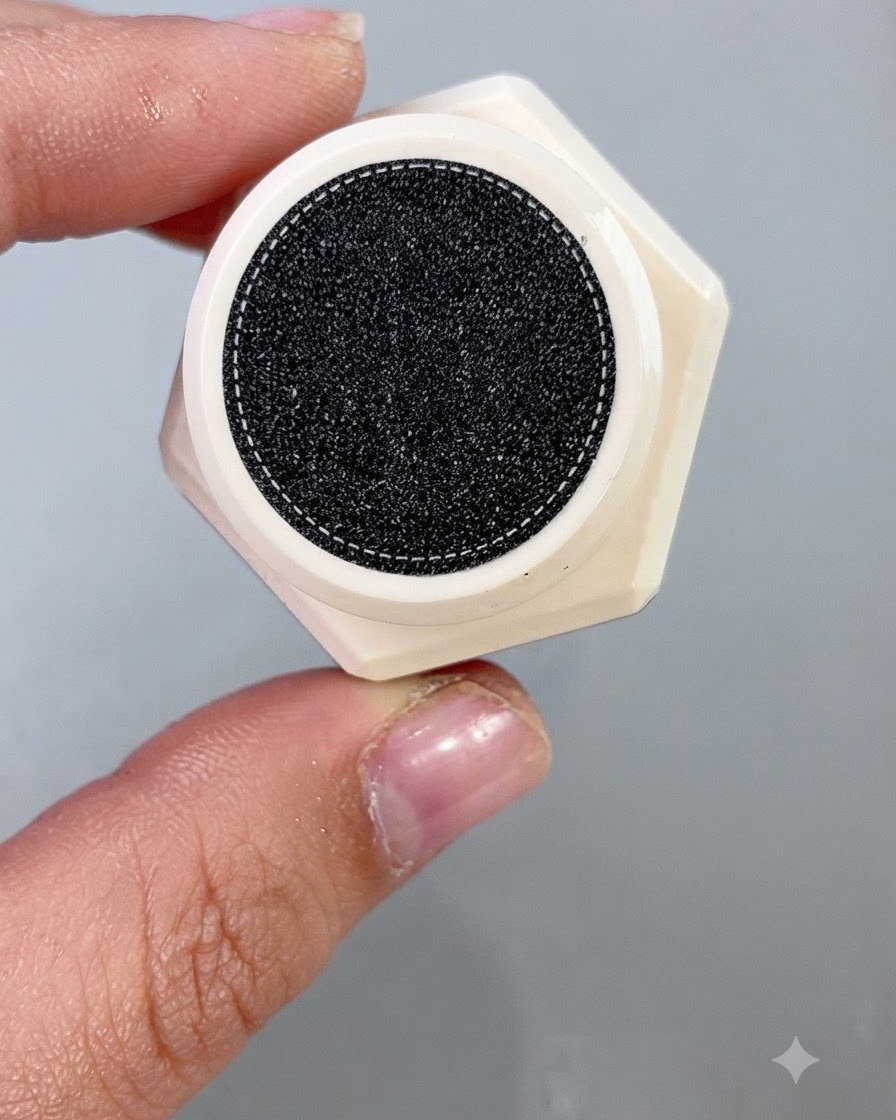 Un pinceau de vernis à ongles appliquant uniformément un gel cat eye cantaloup scintillant sur une fausse capsule dongle.